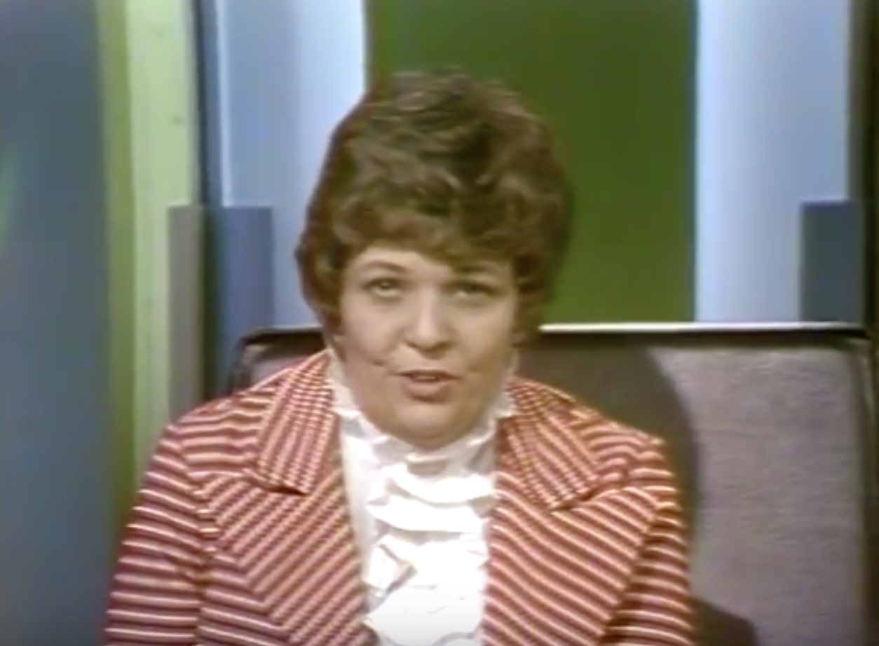 Headshot of Betty Lou Varnum. Screenshot from the video entitled Dimension 5: Gay People Alliance, time 0:30. Varnum is introducing the segment. Follow URL in the caption to see this moment in the video.