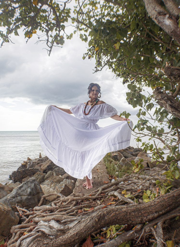 A woman posing in a white Bomba dress