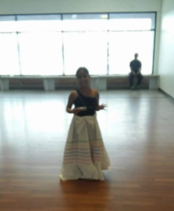 A young person standing in a dance rehearsal room