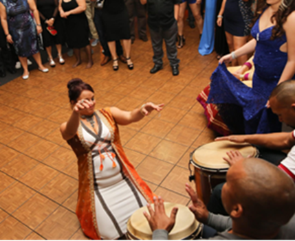 Mujer bailando en el suelo frente a músicos.