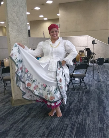 Woman wearing the folkloric Bomba dress with a pink headscarf