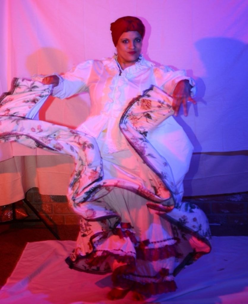 Woman posing in a white Bomba ensemble and a pink headscarf