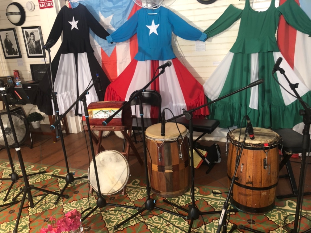 Three Bomba dresses hanged in a wall of a music studio