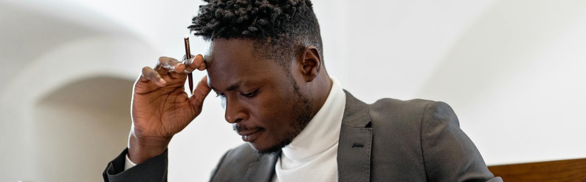 Businessman thinking with his head in his hands.
