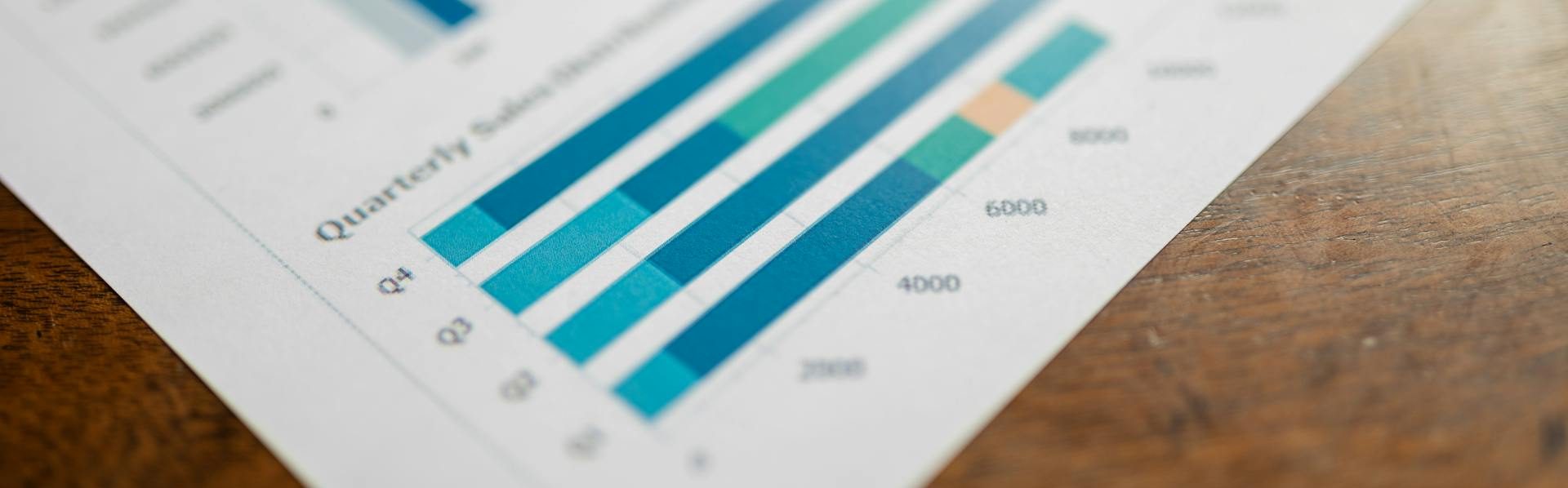 Charts labeled "quarterly earnings reports" printed on a table.
