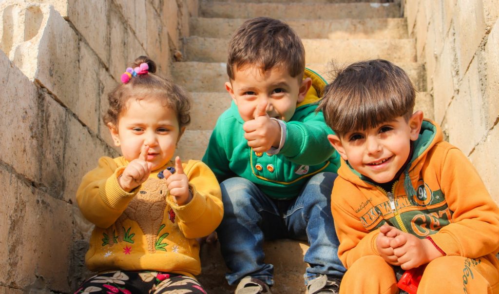 Young children smiling and gesturing