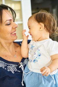 A mother and infant smiling at one another