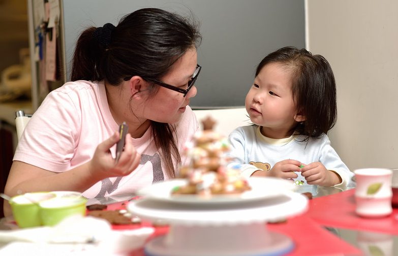 Woman sits at a table with a young child