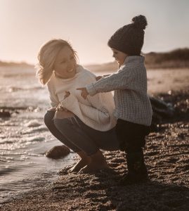 a woman squatting down beside her child who is pointing