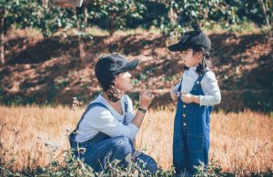 photo of a woman kneeling down looking at a young girl