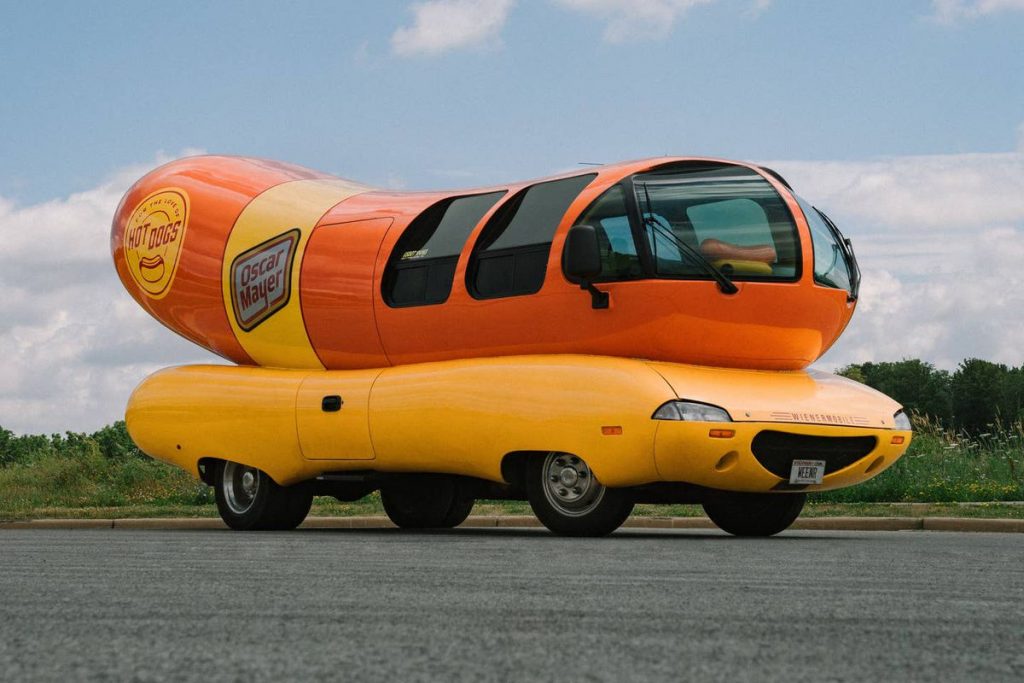 A photo of the iconic Oscar Mayer Weinermobile, a car shaped like a giant hotdog.