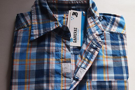 A plaid collared shirt with velcro tabs for closures down the front.