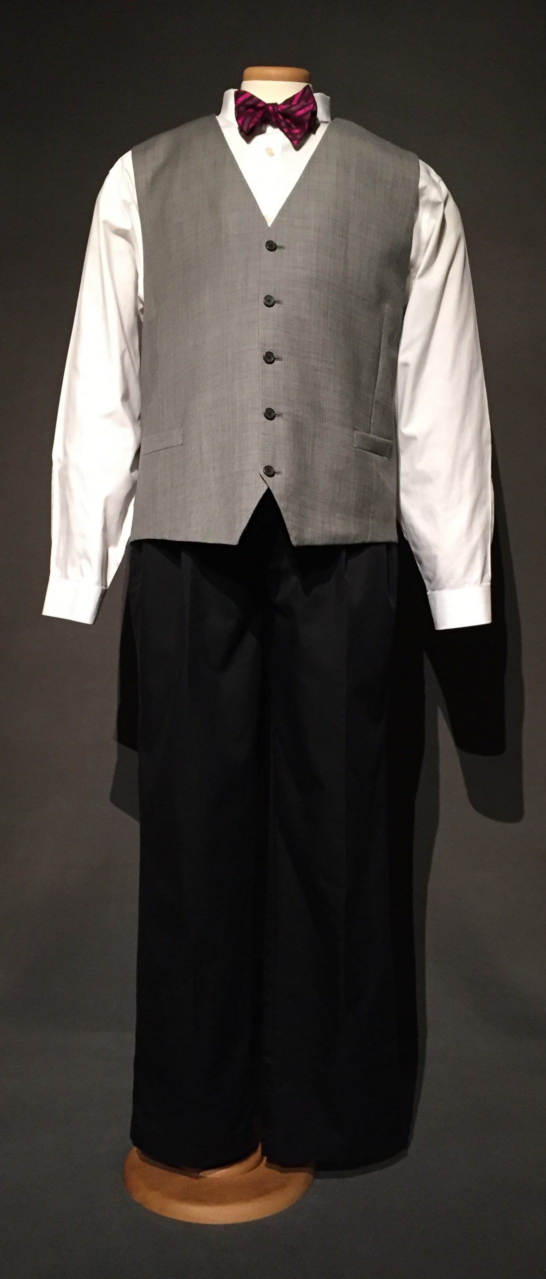 White button down, pink bowtie, grey vest, blue pleated front pant
