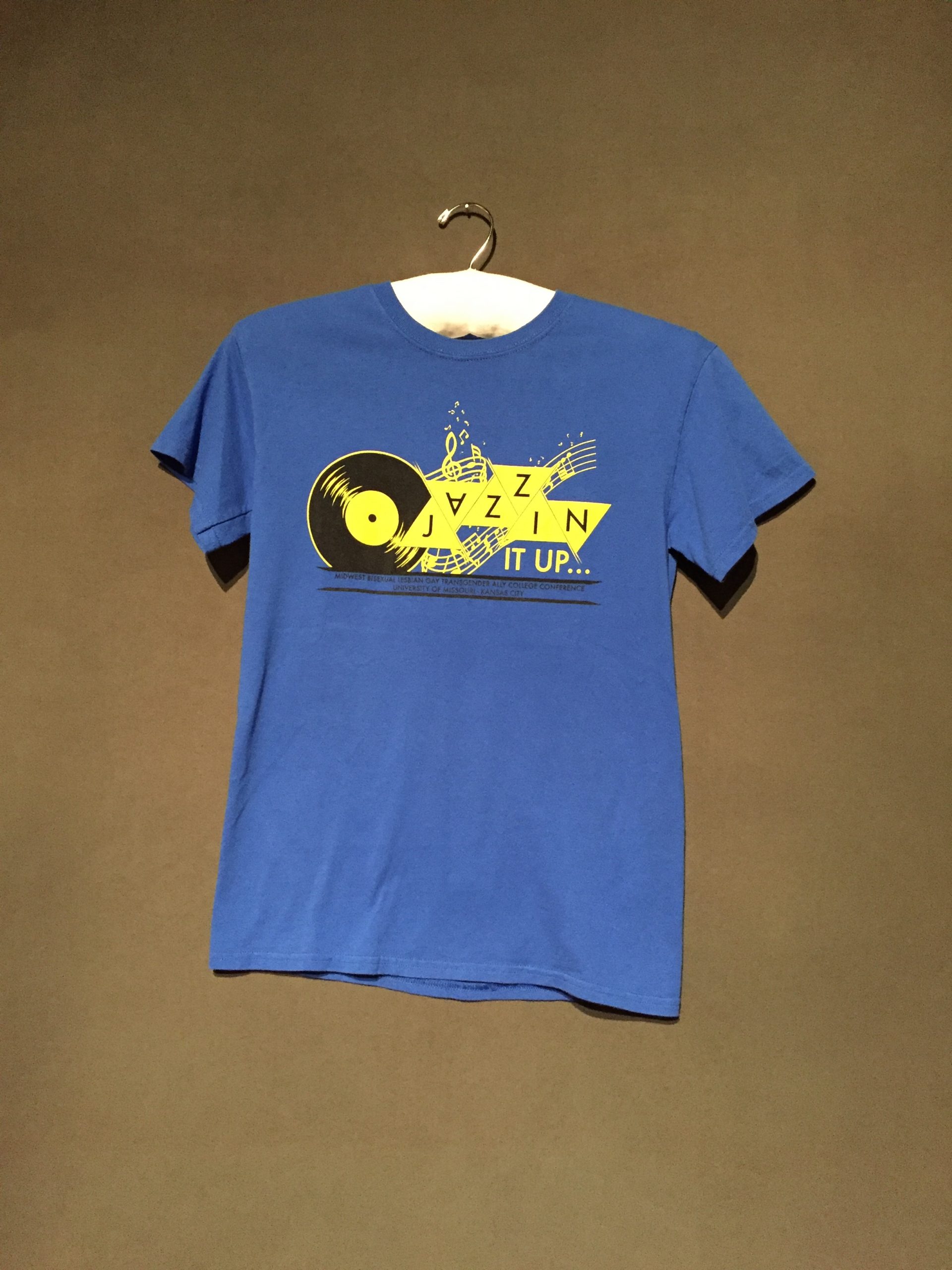 Blue short sleeve t-shirt with yellow music iconography reading "Jazzin It Up..."