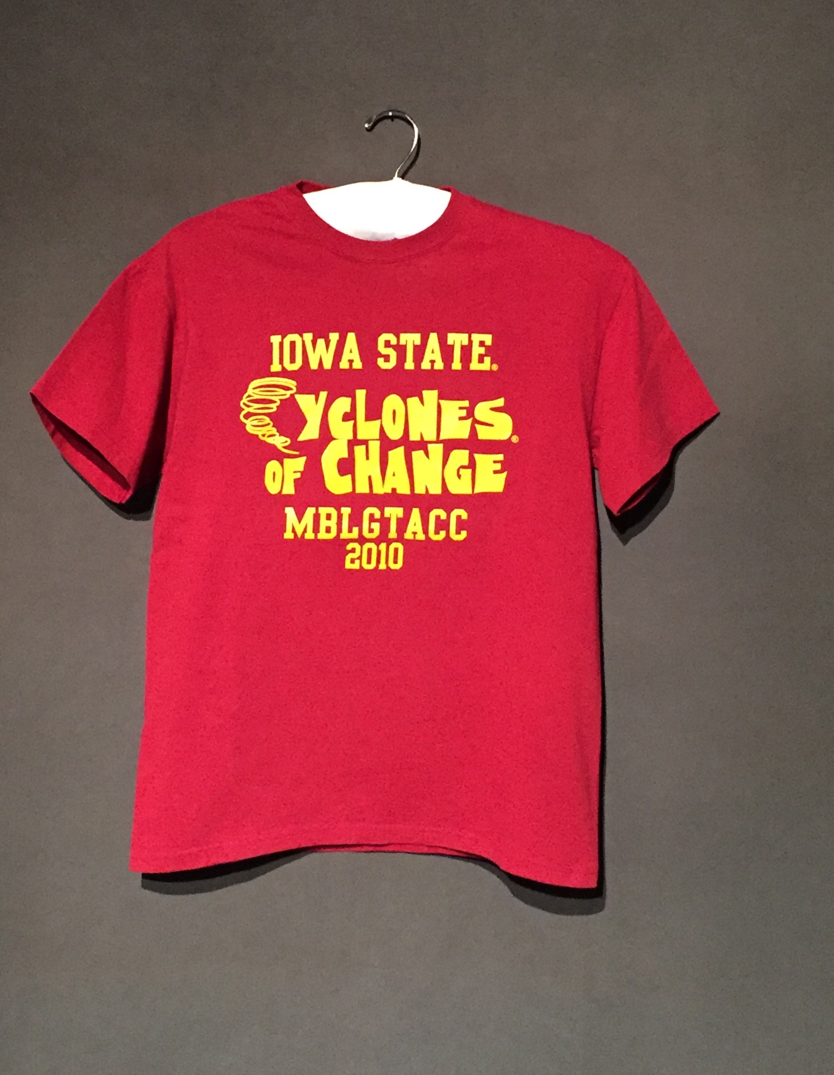 Red short sleeve t-shirt with yellow text reading: Iowa State Cyclones of Change: MBLGTACC 2010"