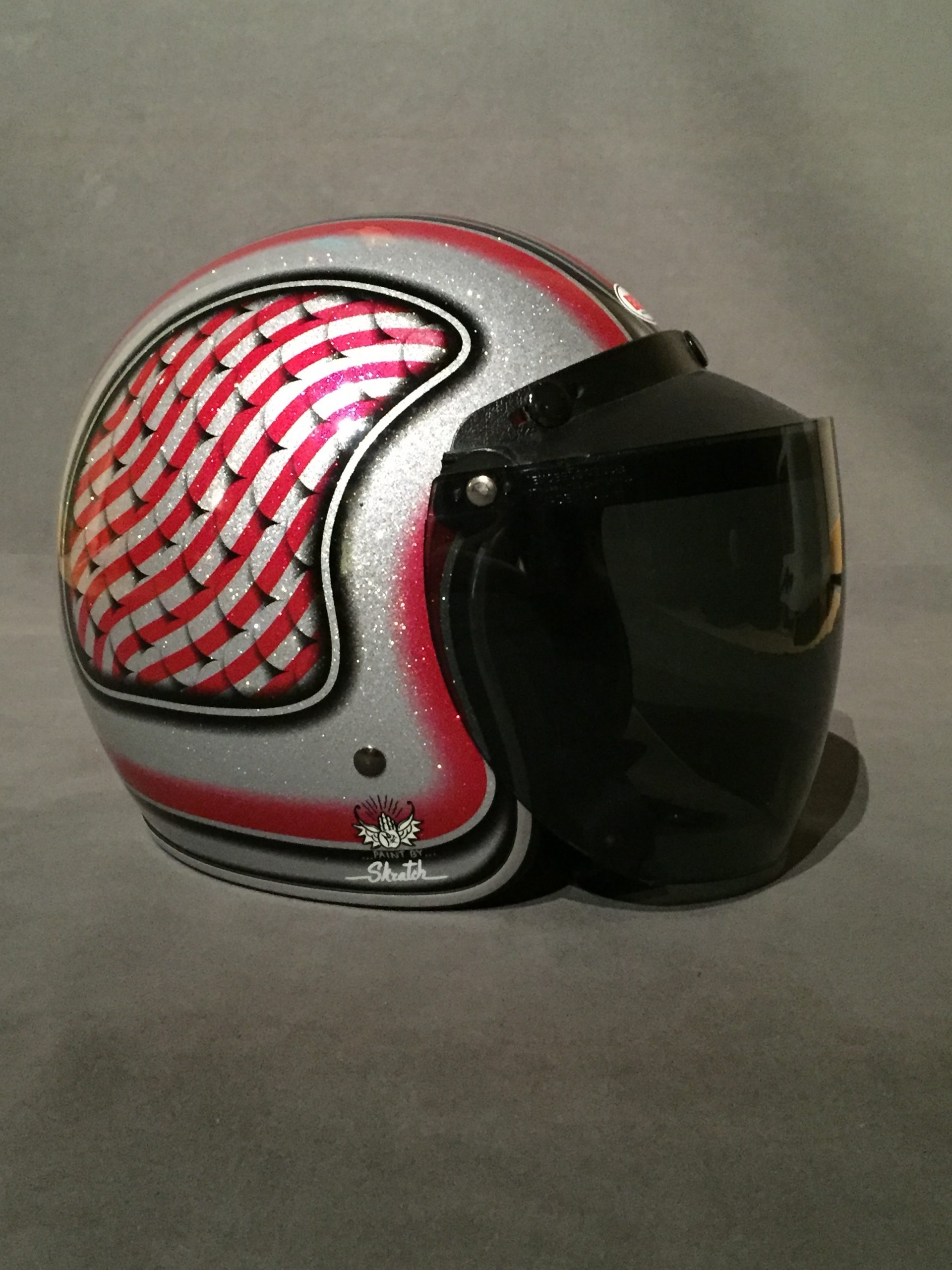 Red and silver motorcycle helmet with black visor.