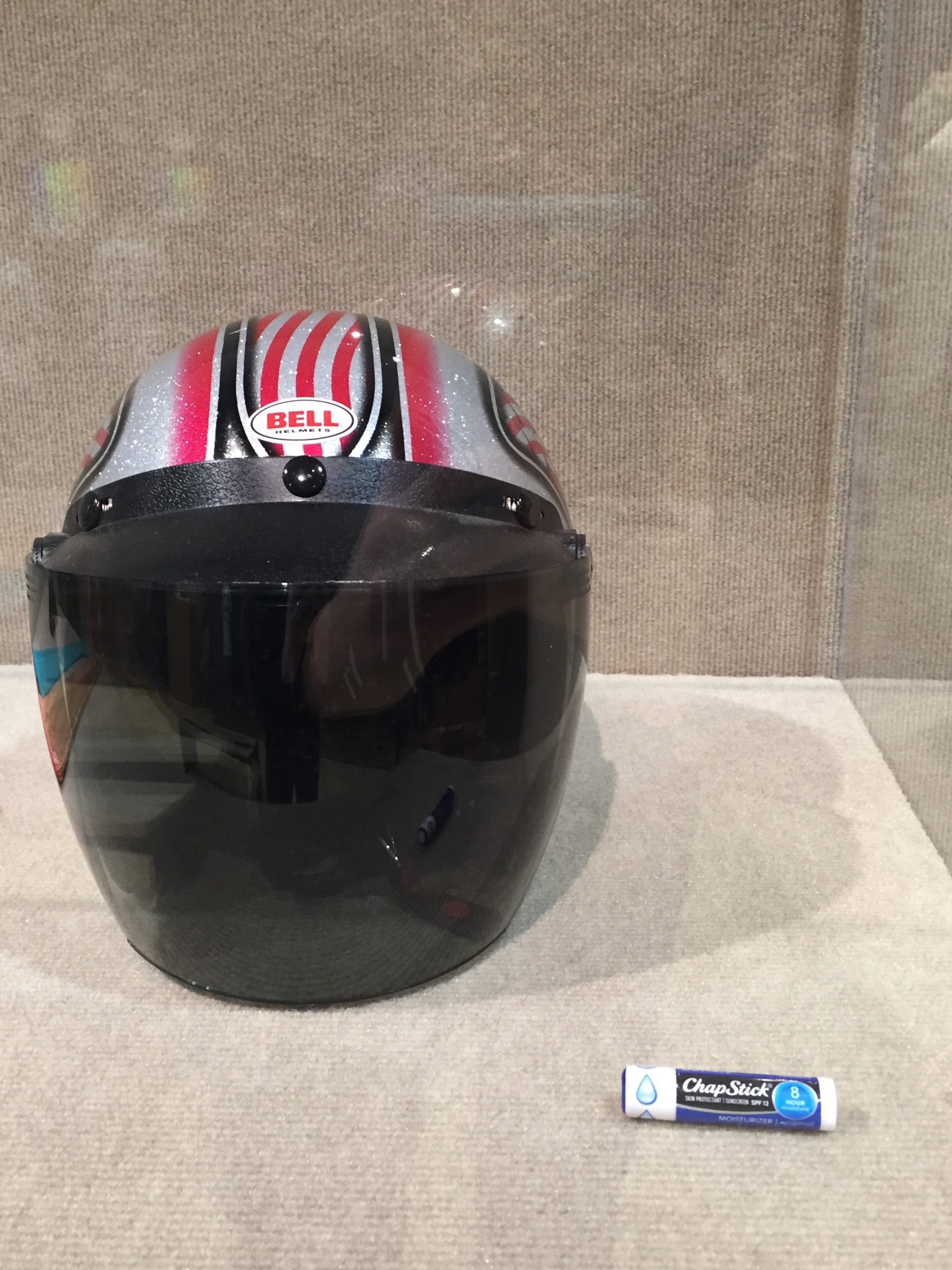 Motorcycle helmet and Chapstick in exhibition case