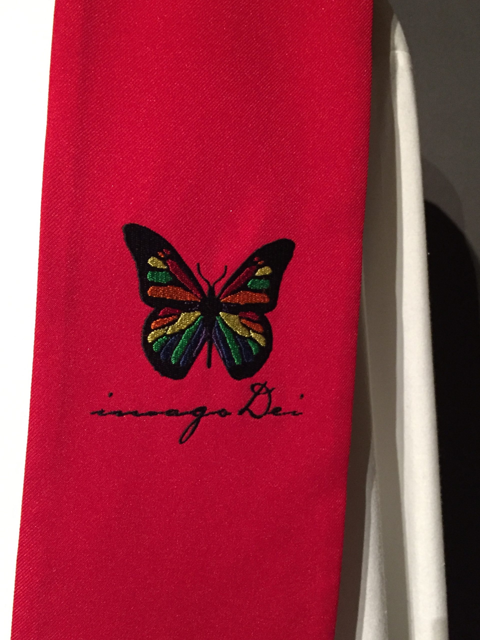 Close-up of rainbow butterfly motif on red stole