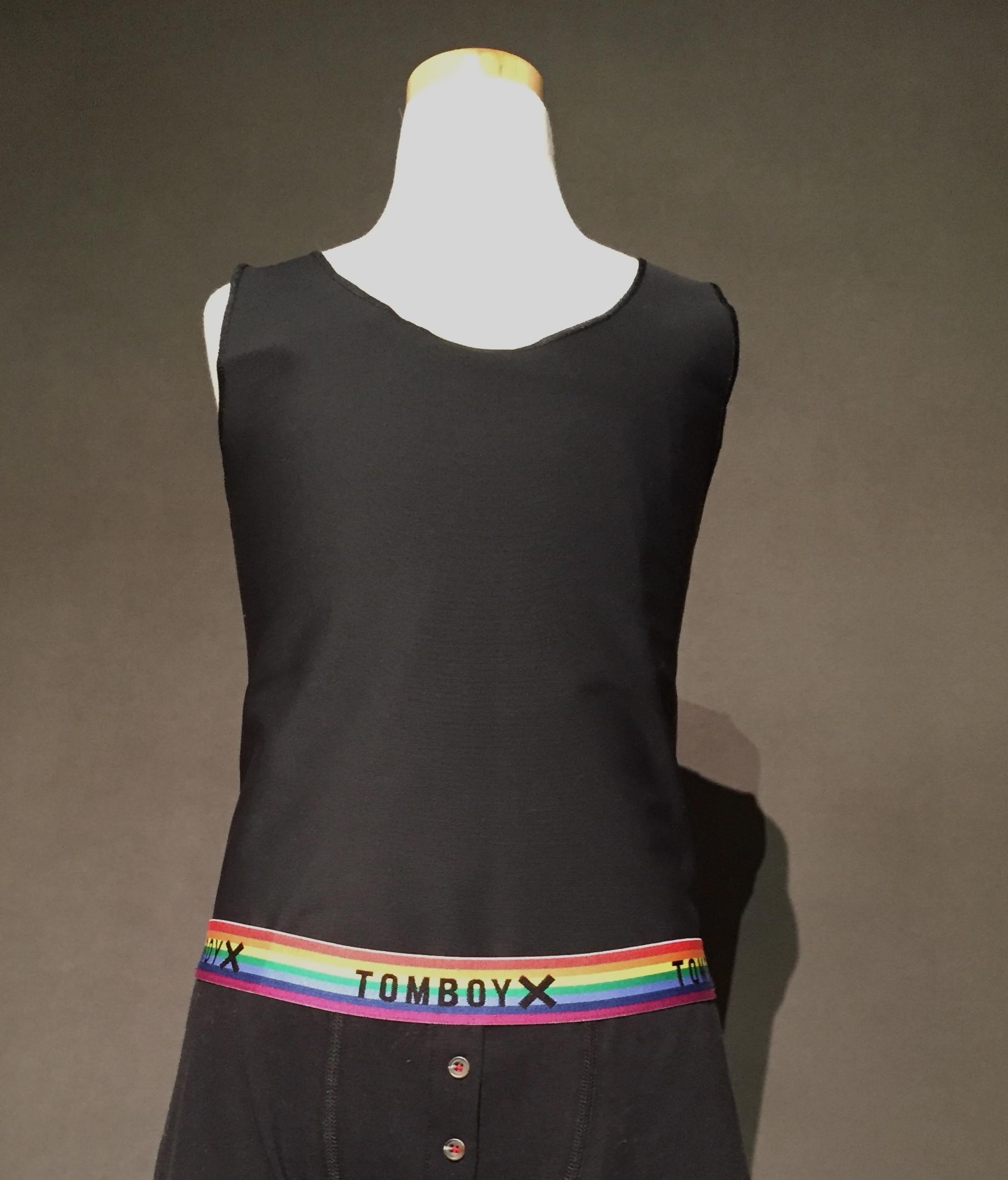 Black binder with boxer briefs with rainbow waistband reading "TomboyX"