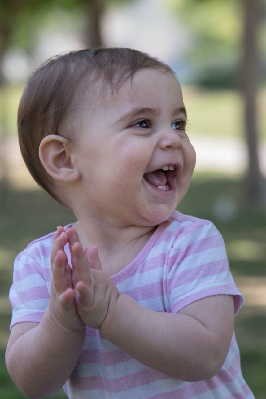 A toddler smiling and clapping