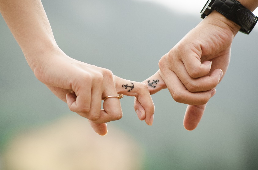 Photo of two people with fingers intertwined.