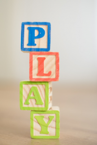 Photo of letter blovks spelling out the word play.
