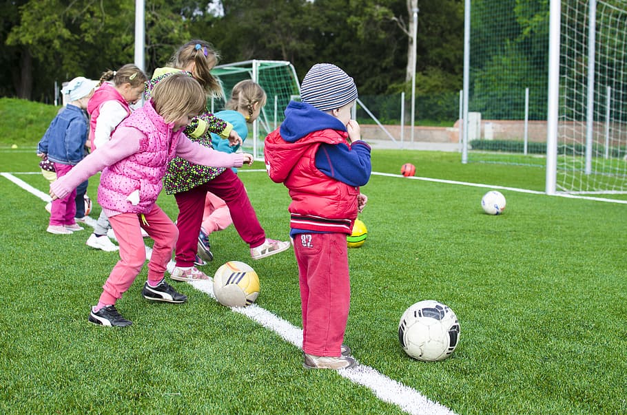 Photo of young children kicking soccer balls