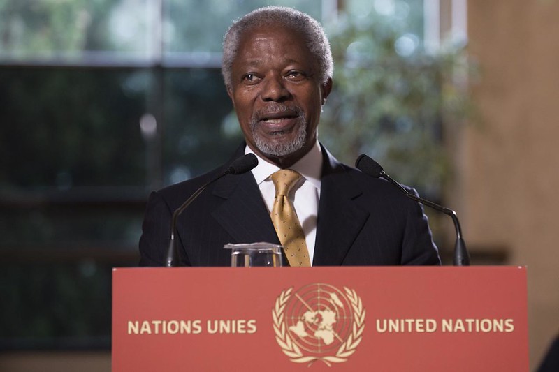 An older black man with a goatee speaks at a podium for the United Nations in a suit.