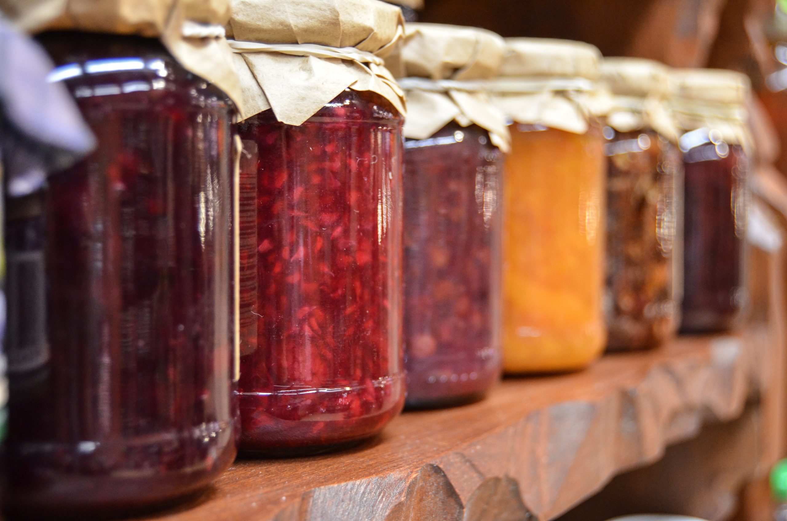 Photo of jars filled with multicolor preserves and jams