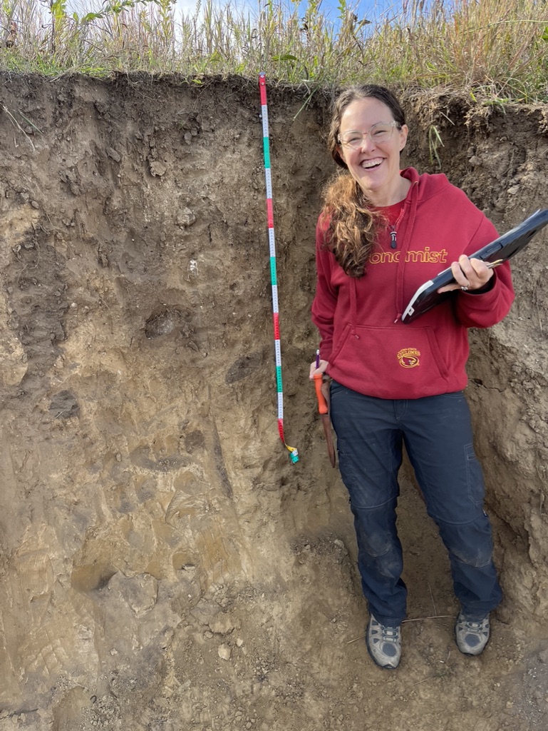 Photo of Amber Anderson smiling in a soil pit.