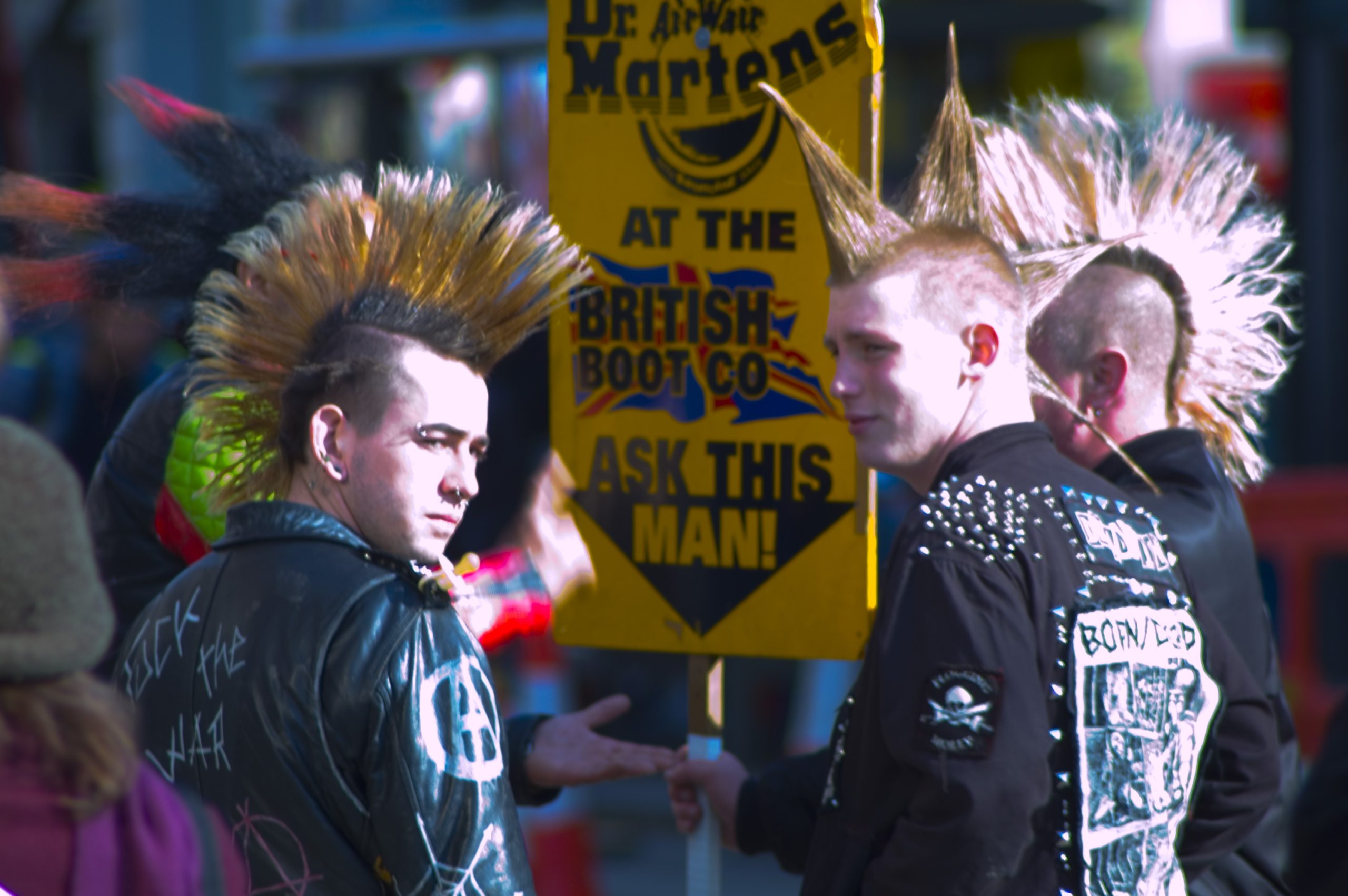 Three men sporting a vibrant mohawk hairstyle, showcasing a bold and unique personal style.